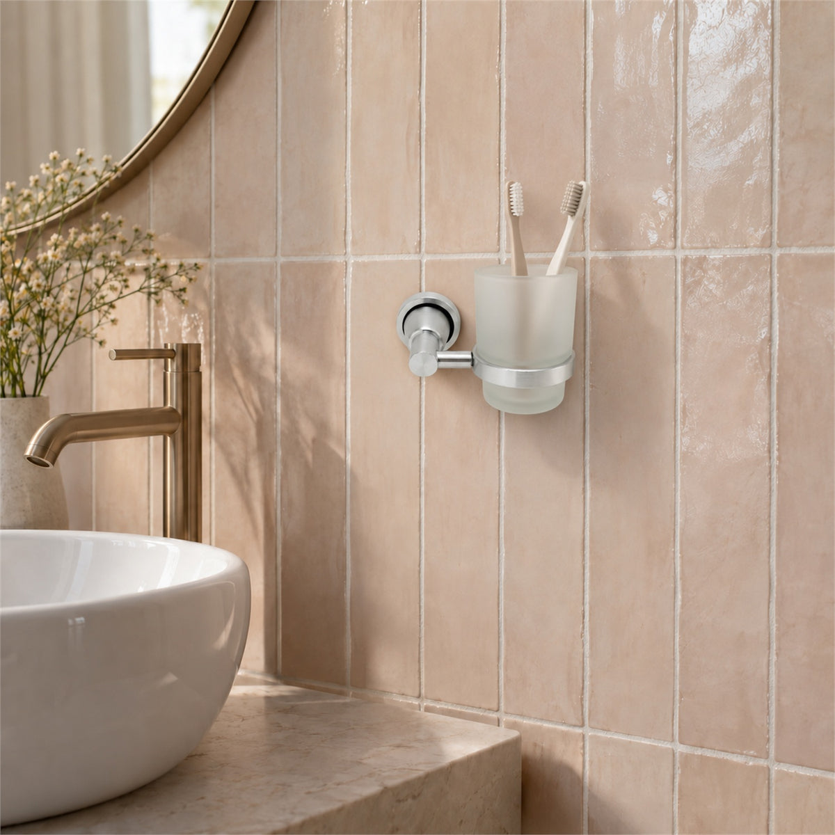 Portavaso mural de aluminio satinado con vaso de cristal ambientado en baño, vista cercana