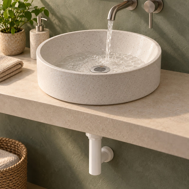 Desagüe plástico con rejilla metálica instalado en lavamanos