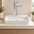 Mezclador alto para lavamanos en acero inoxidable satinado instalado en baño claro