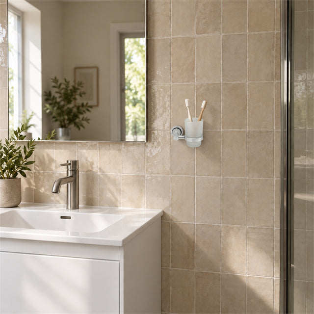 Portavaso mural de aluminio satinado con vaso de cristal ambientado en baño, vista amplia