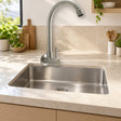 Llave sencilla de pared en acero inoxidable satinado instalada en cocina clara