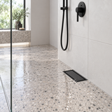rejilla invisible de piso en acero negro de 10 por 20 centímetros instalada en baño contemporáneo, vista amplia