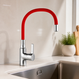 Grifería de cuello flexible rojo instalada en una cocina moderna