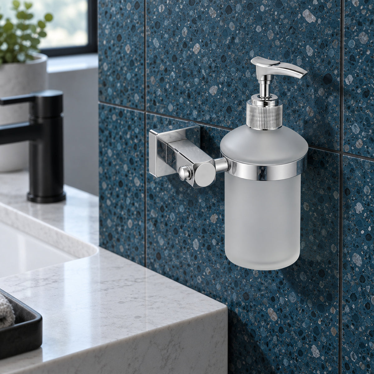 Dispensador mural de jabón con base cuadrada cromada ambientado en baño, vista cercana