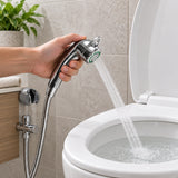 Ducha bidet cromada sostenida por una mano durante prueba de agua