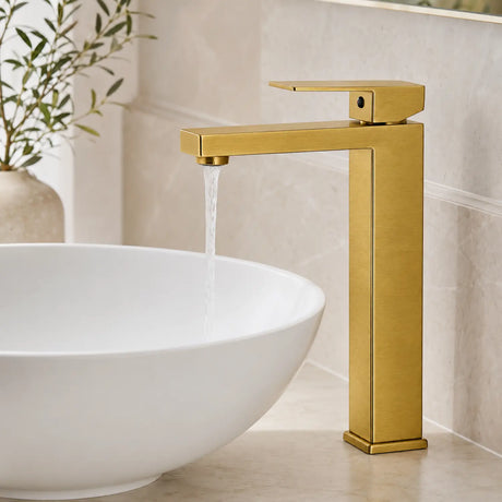 Grifería Paris 5384 oro cepillado en uso con agua cayendo dentro del lavamanos