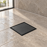 Rejilla de piso invisible negro mate instalada en piso de ducha