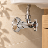 Válvula de regulación plástica cromada de media pulgada en una escena de baño. Instalación ilustrativa; los demás elementos no están incluidos.