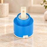 Cartucho para monocontrol de ducha de 40 mm suelto sobre piedra cálida antes de instalar; accesorios del ambiente no incluidos.