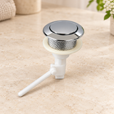 Botón Push de repuesto para sanitario suelto sobre piedra cálida antes de instalar; accesorios del ambiente no incluidos.