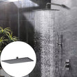 Regadera rectangular Kassel gunmetal instalada en una ducha moderna