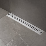 Rejilla lineal de acero brillante drenando agua en ducha