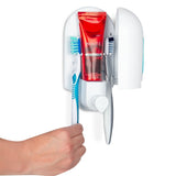 Fotografía oficial del dispensador abierto mostrando el alojamiento del tubo y el espacio para dos cepillos; crema dental y cepillos ilustrativos.