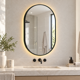 Espejo Aura LED indirecto ovalado 50 × 80 cm negro antiempañante, ambientado en baño moderno