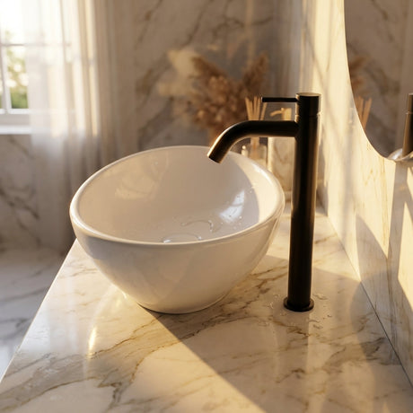 Over-the-shoulder view of black lavamanos on marble countertop during golden hour, emphasizing luxurious textures and installation details.