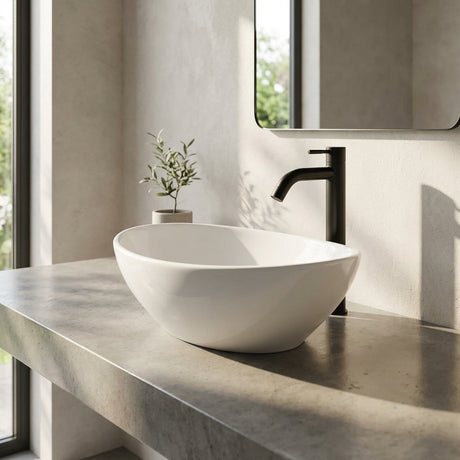 Full-body view of oval-shaped black lavamanos on modern bathroom countertop, showcasing seamless installation and dimensions in natural daylight.
